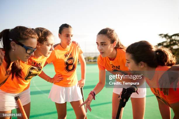 team huddle: teen female hockey players listen to captain's words - team captain stock pictures, royalty-free photos & images