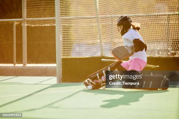 crucial save: teen hockey goalkeeper protects the net - hockey goalkeeper stock pictures, royalty-free photos & images