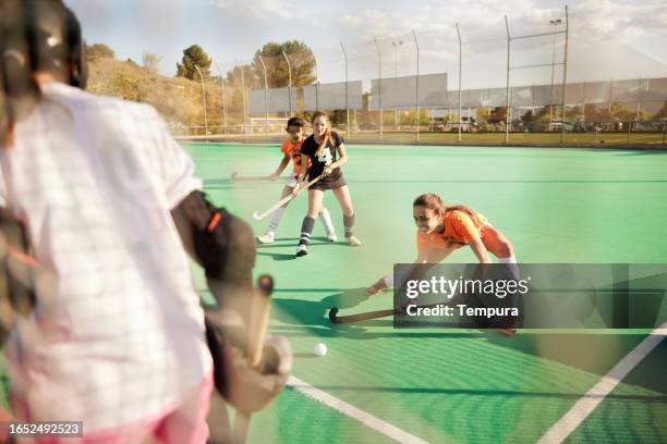 teenage hockey player: girl engaged in hockey game - youth sports competition stock pictures, royalty-free photos & images