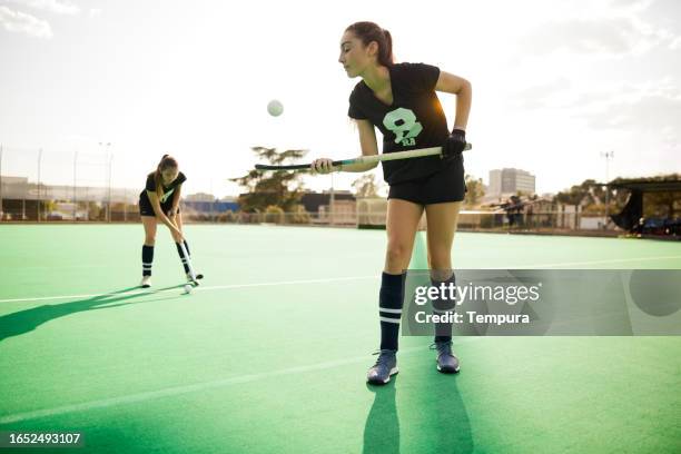 calentamiento hábil: jugadora adolescente de hockey sobre césped equilibra la pelota en el palo. - hockey warm up fotografías e imágenes de stock