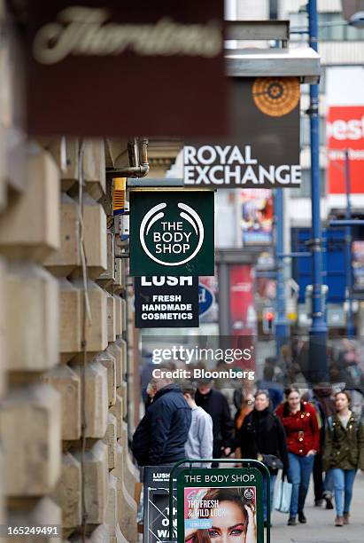 Pedestrians pass a sign outside a Body Shop International Plc store in Manchester, U.K., on Monday, April 1, 2013. U.K. Retail sales unexpectedly...