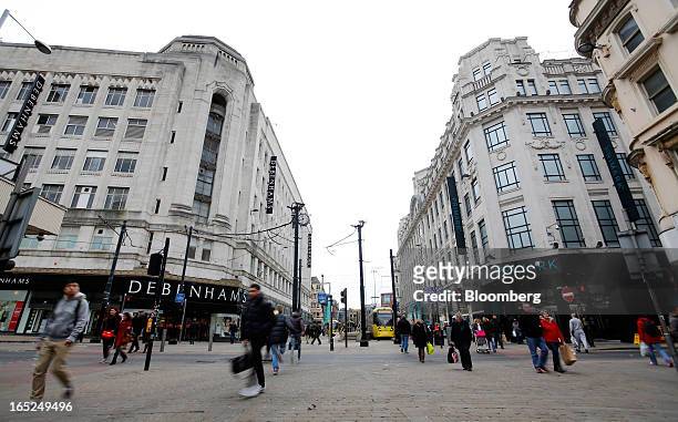 Pedestrians pass a Debenhams Plc department store, left, and a Primark store, operated by Associated British Foods Plc, right, in central Manchester,...