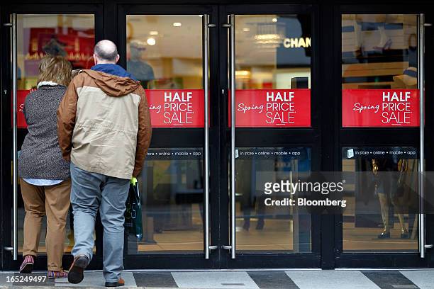 Customers enter a Debenhams Plc department store advertising a half price sale in central Manchester, U.K., on Monday, April 1, 2013. U.K. Retail...