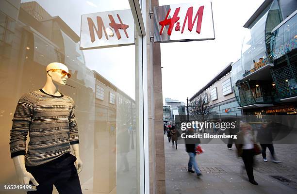 Pedestrians pass the window display of a Hennes & Mauritz AB fashion store in Manchester, U.K., on Monday, April 1, 2013. U.K. Retail sales...