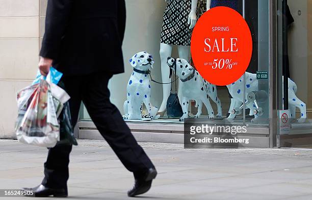 Pedestrian passes a sale sign in the window of a Hobbs store in Manchester, U.K., on Monday, April 1, 2013. U.K. Retail sales unexpectedly stagnated...