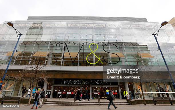 Pedestrians pass a Marks & Spencer Group Plc store in Manchester, U.K., on Monday, April 1, 2013. U.K. Retail sales unexpectedly stagnated in March...
