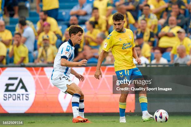 Munir El Haddadi of UD Las Palmas competes for the ball with Aihen Munoz of Real Sociedad during the LaLiga EA Sports match between UD Las Palmas and...