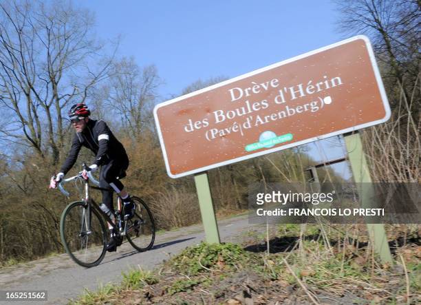 Cyclist rides on the Arenberg cobblestoned road on the route of Paris-Roubaix cycling race on April 2, 2013 in Haveluy, northem France, five days...
