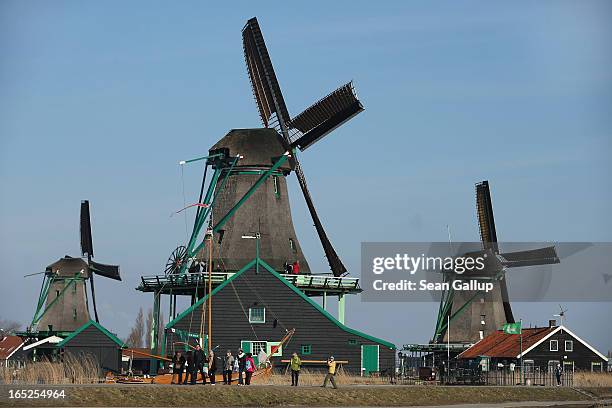 Visitors walk past still-functioning windmills at the Zaanse Schans outdoor mueseum on April 1, 2013 in Zaandijk, Netherlands. Zaanse Schans,...