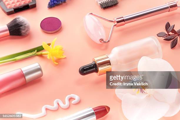 collection  of beauty cosmetic products and flowers of orchid and daffodil on pastel pink background. - fuchsia orchids stock pictures, royalty-free photos & images
