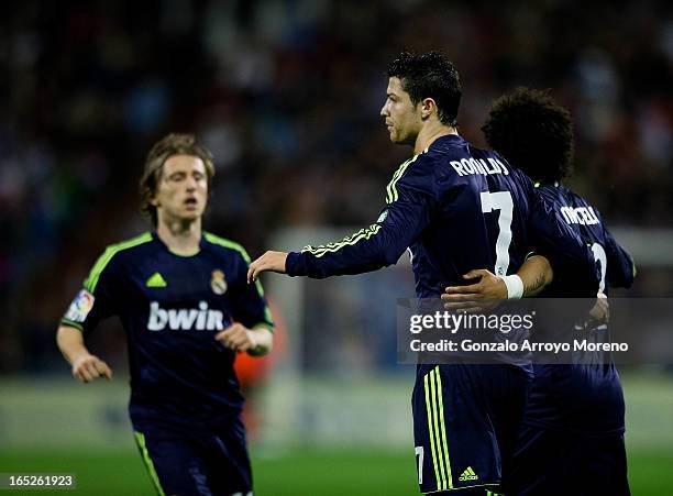 Cristiano Ronaldo of Real Madrid CF celebrates scoring their opening goal with team-mates Marcelo and Luka Modric during the La Liga match between...