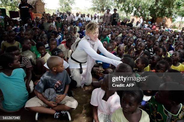 Pop Star Madonna interacts with Malawian children at Mkoko Primary School on April 2, 2013 in the region of Kasungu, central Malawi, one of the...