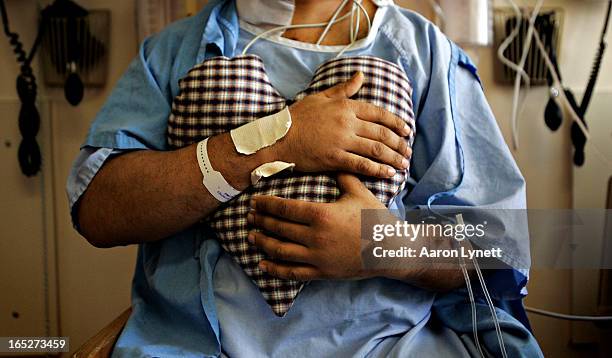 Ashok Verma holds a heart-shaped pillow to his chest as the light pressure helps alleviate the pain he feels as he is out of bed for the first time...