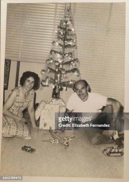 spanish couple sitting near christmas tree - caracas christmas stock pictures, royalty-free photos & images