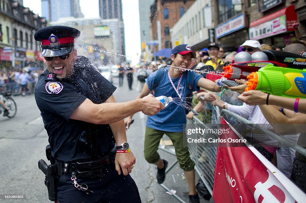 Toronto Police officer has water fight with party goers in the annual Pride Parade in Toronto on Jul