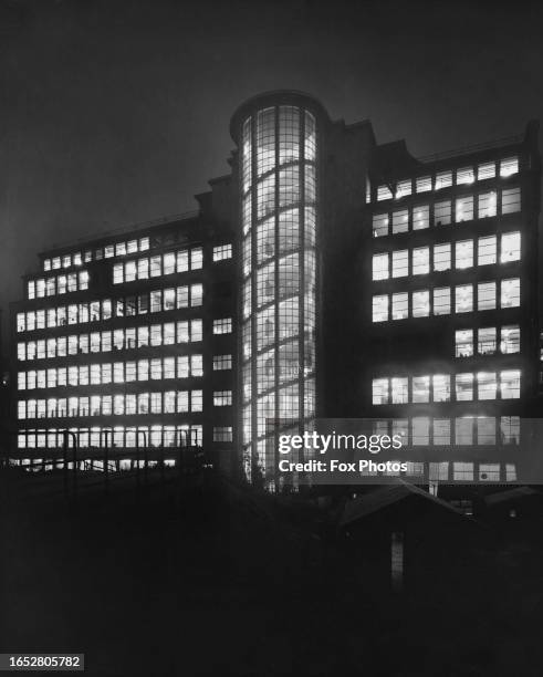 St Bridget's House, its windows and stairwell illuminated by night, on Bridewell Place in Blackfriars, City of London, England, circa 1955. The...