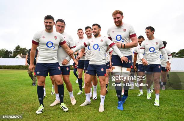 Danny Care of England holds his team mates back to let Owen Farrell of England enter the field on his own as a joke during a training session at...