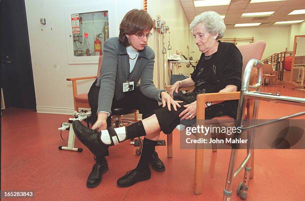 Murray with Faye Grupp, teaching her to use walker and also some leg exercises with weight on ankle.