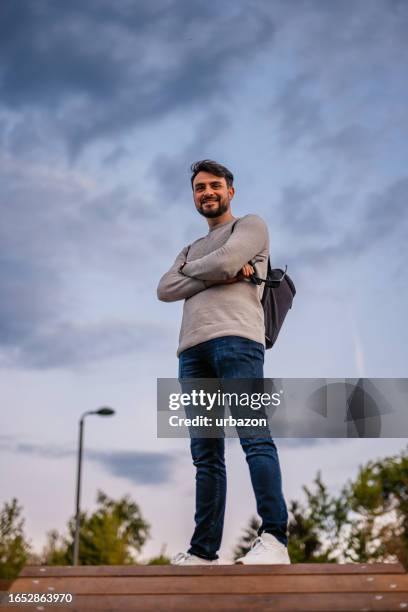 man in the city park on a cloudy spring morning - low angle view stock pictures, royalty-free photos & images