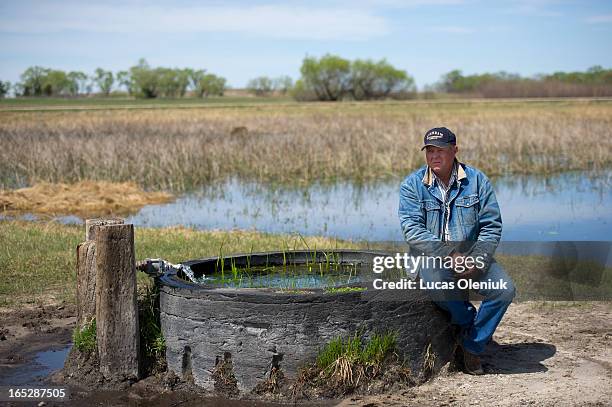 Organic rancher Bruce Boettcher sits on a flowing well on his Sand Hills property. Boettcher is fighting TransCanada to move the Keystone XL pipeline...