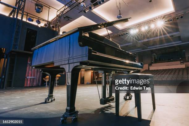 grand piano on stage facing empty theatre auditorium - classical orchestral music stock pictures, royalty-free photos & images
