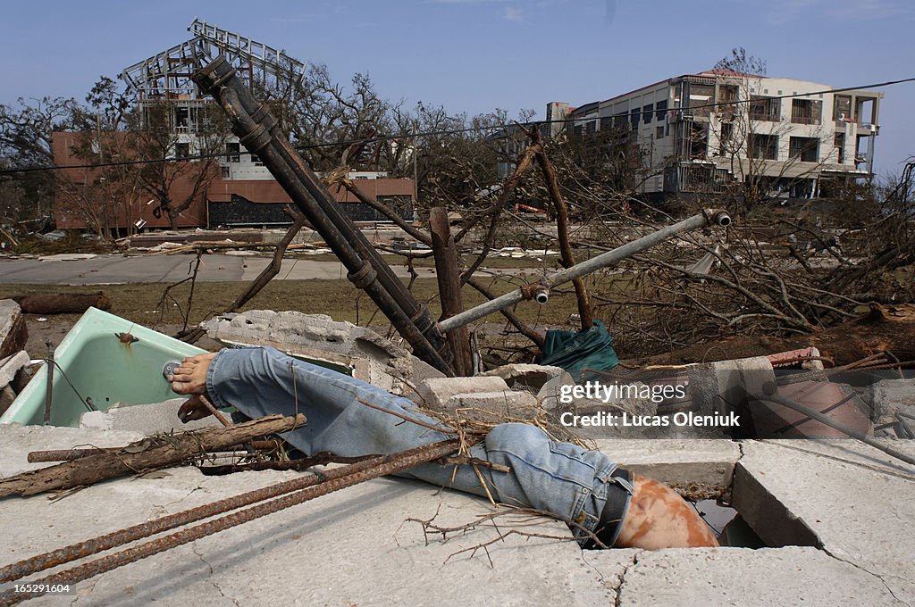 A male victim of Hurricane Katrina rests tangled underneath a concrete slab of a devestated motel in