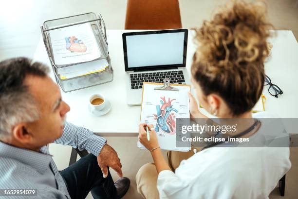 le patient et le médecin examinent les résultats - rythme cardiaque photos et images de collection