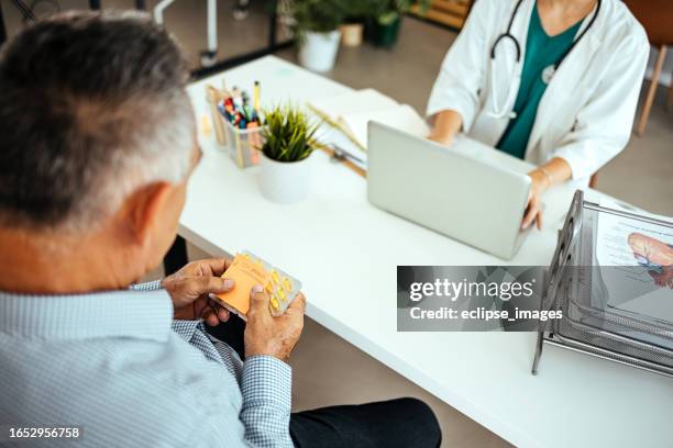 female doctor gives medicine to patient - elderly receiving paperwork stock pictures, royalty-free photos & images