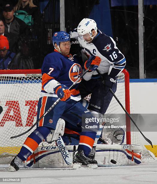 Matt Carkner of the New York Islanders moves Andrew Ladd of the Winnipeg Jets out of the crease at the Nassau Veterans Memorial Coliseum on April 2,...