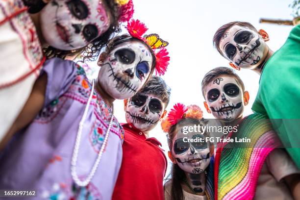 portrait of children with sugar skull face paint during day of the dead celebration - dag-van-de-doden stockfoto's en -beelden