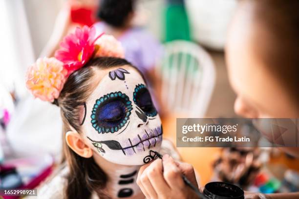 une fille se maquille pour le visage comme crâne de sucre pour le jour des morts - la calavera catrina photos et images de collection