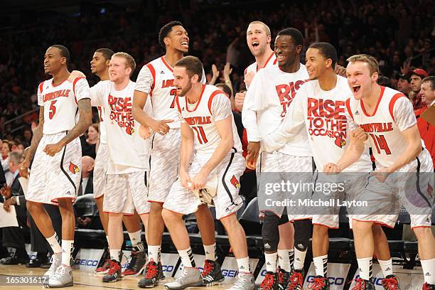 The Louisville Cardinals bench celebrate a basket during the finals of the Big East Basketball Tournament against the Syracuse Orange at Madison...