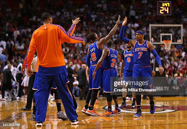 Carmelo Anthony of the New York Knicks high fives teammates during a game against the Miami Heat at American Airlines Arena on April 2, 2013 in...
