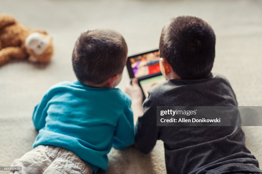 Children playing video game on floor together