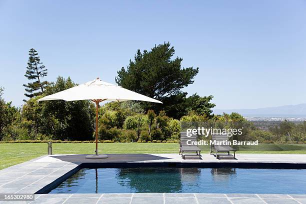 swimming pool, lounge chairs and umbrella - parasols stockfoto's en -beelden