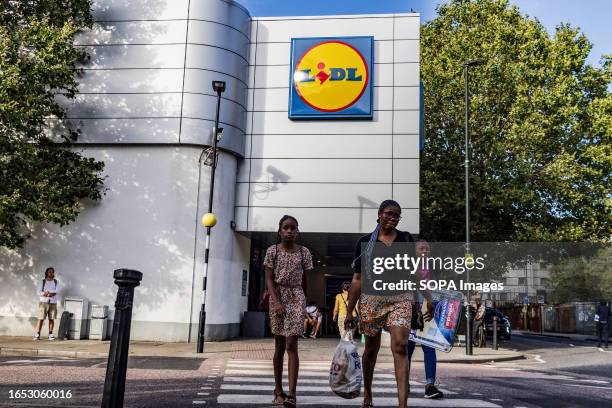 People walk past a Lidl store in London. Lidl is a chain of German-headquartered supermarkets.