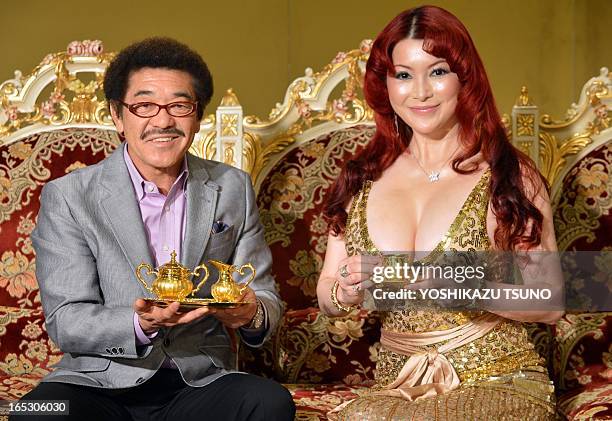 Japanese Mika Kano and former world boxing champion Yoko Gushiken display a gold made cup and saucer set, priced at 7 million yen and a sugar bowl...