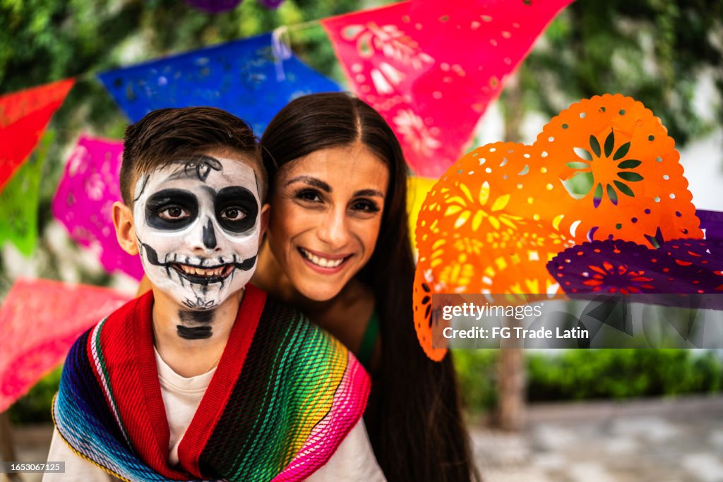 Retrato de madre e hijo con calavera de azúcar pintado durante la celebración del día de muertos