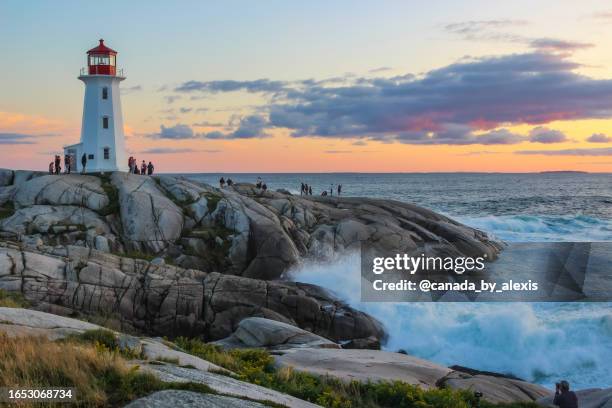 waves crashing on the lighthouse rocks - peggys cove stock pictures, royalty-free photos & images