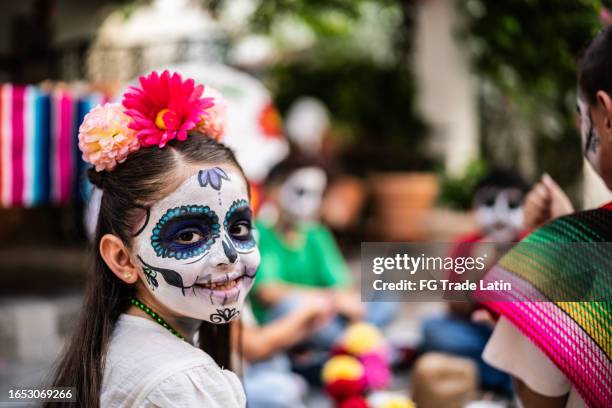 retrato de una niña con calavera de azúcar pintada durante la celebración del día de los muertos - catrina fotografías e imágenes de stock
