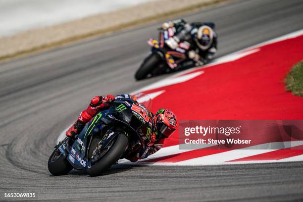Fabio Quartararo of France and Monster Energy Yamaha MotoGP rides in front of Raul Fernandez of Spain and CryptoDATA RNF MotoGP Team during the free...