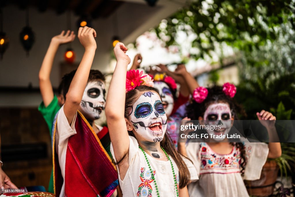Niños jugando y celebrando durante la celebración del día de la muerte al aire libre