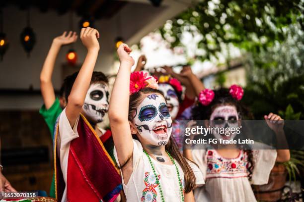 niños jugando y celebrando durante la celebración del día de la muerte al aire libre - catrina mexico fotografías e imágenes de stock