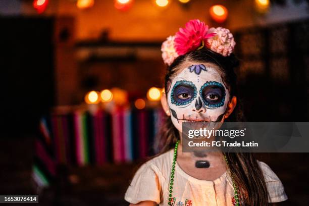 portrait of girl with sugar skull face paint during day of the dead celebration - sugar skull stockfoto's en -beelden