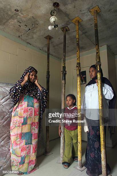 Asha Hassan, left, stands in a bedroom which the family hasn't been able to use in almost two monthes. Several members of the family sleep together...