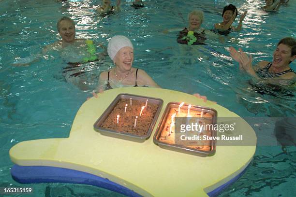 Surprised with a pair of floating cakes Anni Mohren celebrates her 80th birthday at her YMCA aqaufit class in Toronto, January 14, 2002. ."She is...