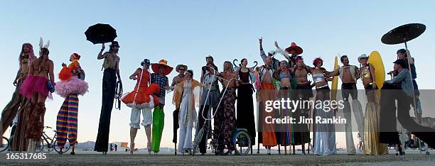 Stilt walkers pose for a group shot after sunset at Burning Man, an arts festival and party that transforms the desert into a city of 35,000 for a...