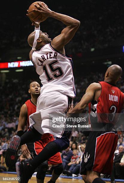 Vince Carter @#15 splits the defence as the Toronto Raptors visit the New Jersey Nets in Game Three at the Continental Airlines Arena in East...