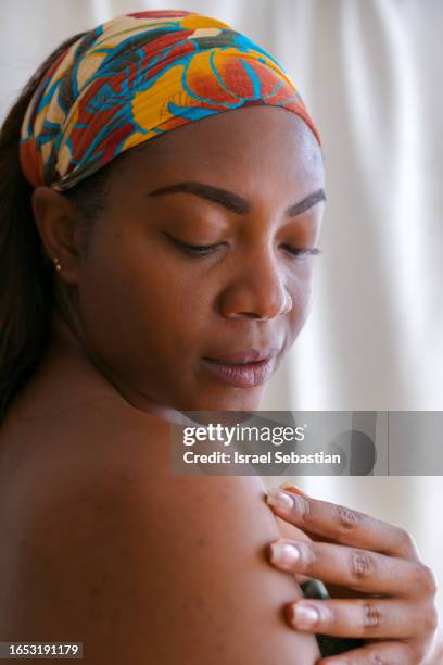beautiful latin american woman in skincare and beauty routine studio shoot. - rubbing stock pictures, royalty-free photos & images
