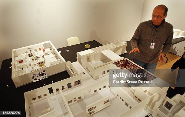 At the AGO, curator of Canadian Art Gerald McMaster shows a scale model complete with scale copies of paintings to plan the display of the works....